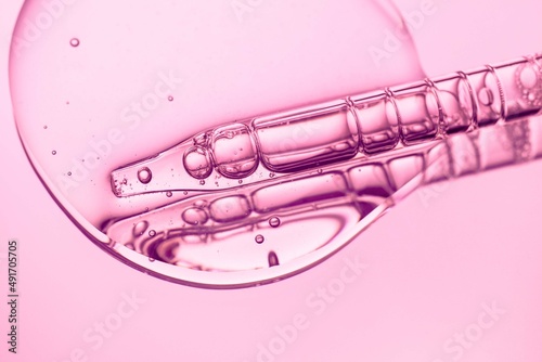 Liquid pipette serum pink gel on light berry retinol hyaluronic acid colored mirror background