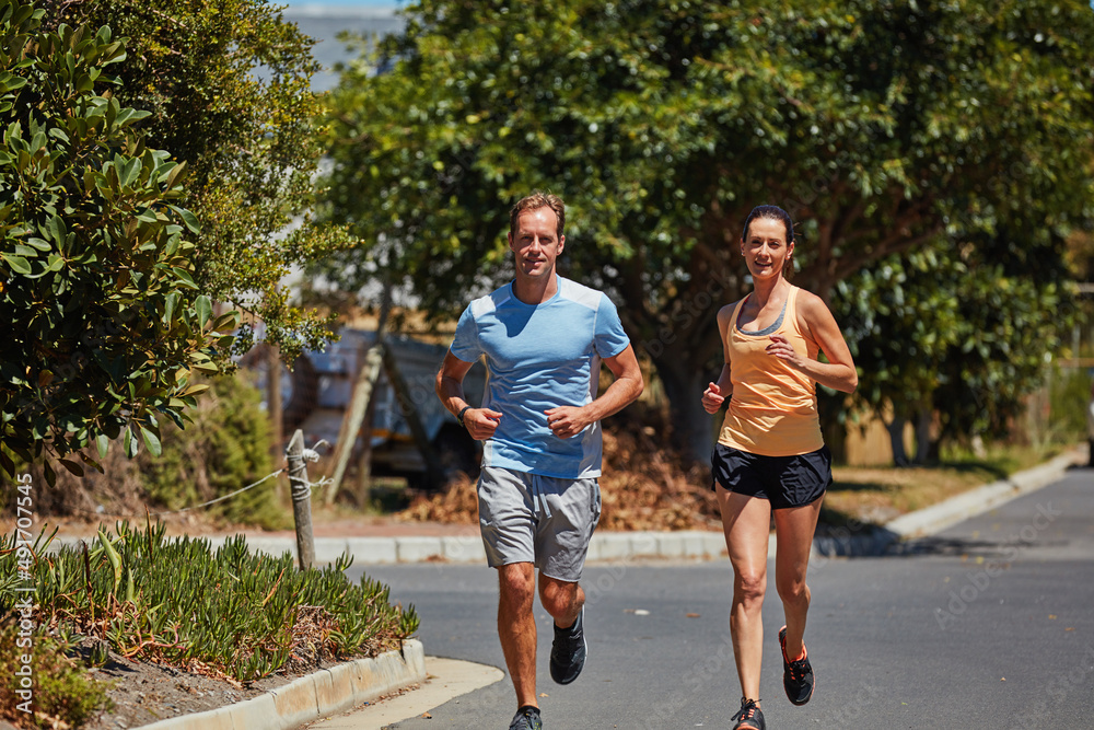 The only bad workout is the one you didnt do. Shot of a happy couple jogging together in their neighborhood.