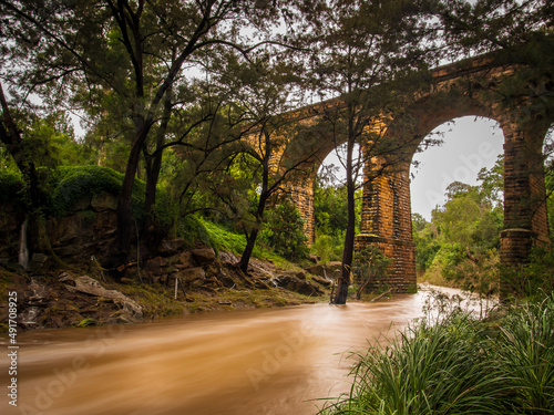 Historic railway viaduct with flooded creek below photo