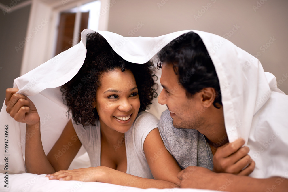 Fun under the covers. A cute couple underneath the covers. Stock Photo