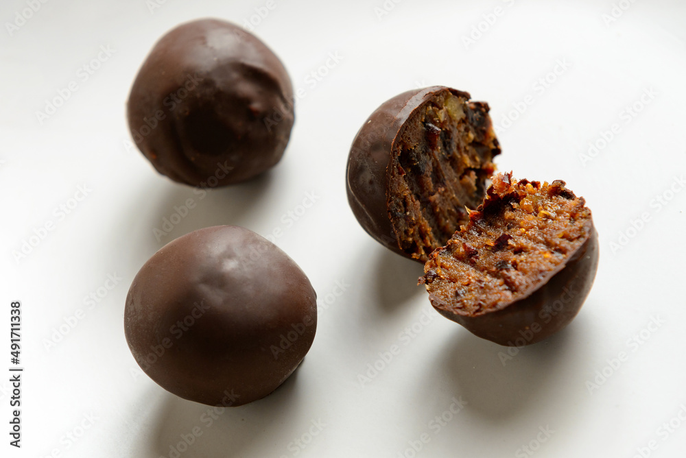 sliced vegan chocolate candy with figs and prunes on a white plate, close-up sliced vegan chocolate candy with figs and prunes on a white plate, close-up