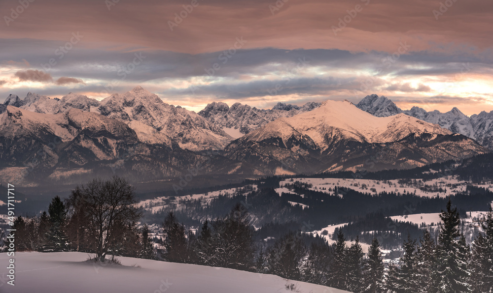 panorama of the snowy Tatra Mountains against the backdrop of the setting sun - obrazy, fototapety, plakaty 