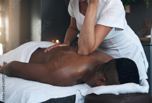 Working out the tension. Shot of a young man getting a back massage at a spa.