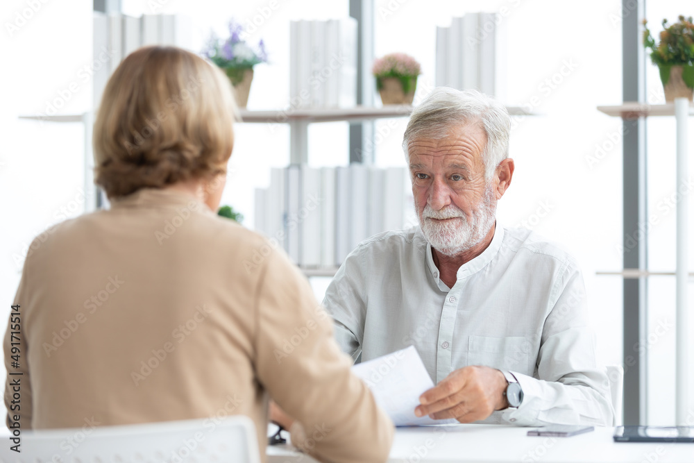senior businessman or employer asking and talking about works to coworker