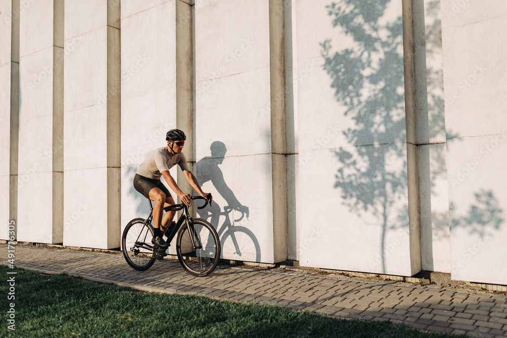 Fototapeta premium Muscular man riding sport bike during sunny day outdoors