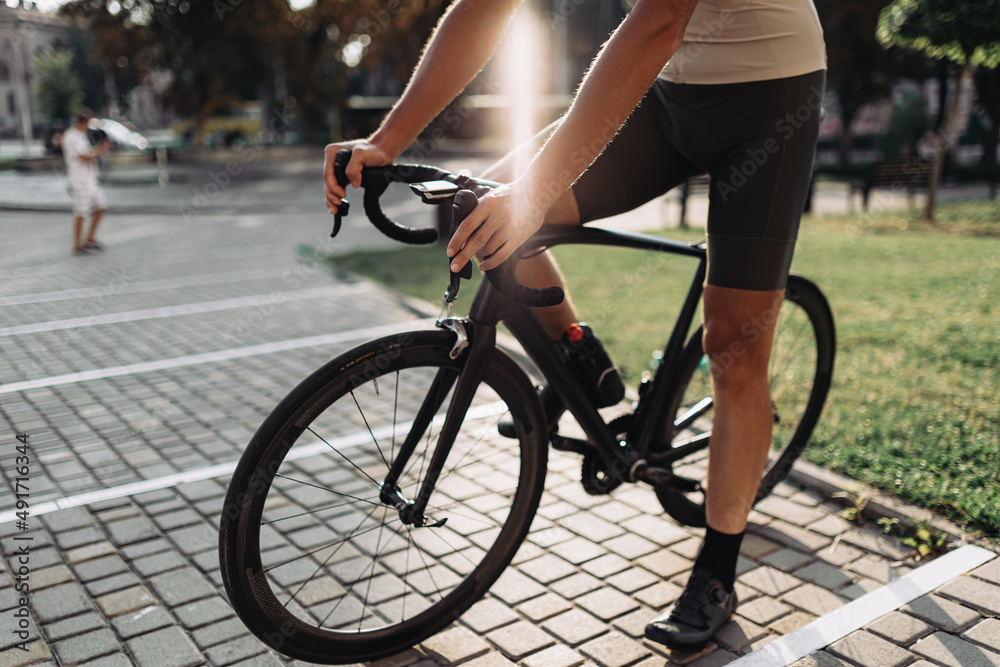 Fototapeta premium Close up of cyclist in sportswear sitting on bike outdoors