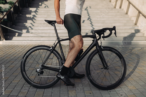 Close up of cyclist in sportswear standing with bike