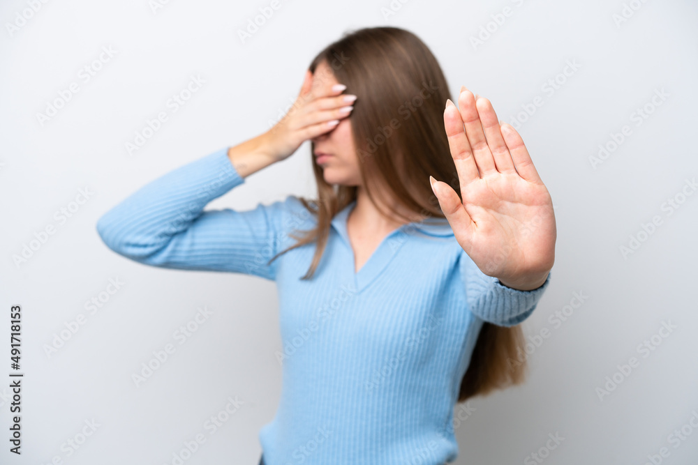 Young Lithuanian woman isolated on white background making stop gesture and covering face Young Lithuanian woman isolated on white background making stop gesture and covering face