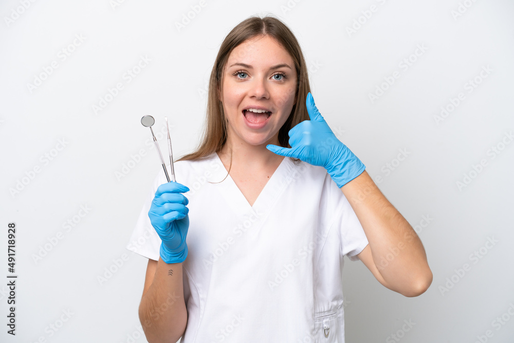 Dentist woman holding tools isolated on white background making phone gesture. Call me back sign Dentist woman holding tools isolated on white background making phone gesture. Call me back sign