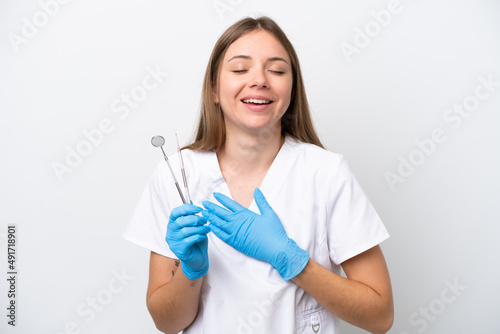 Dentist woman holding tools isolated on white background smiling a lot