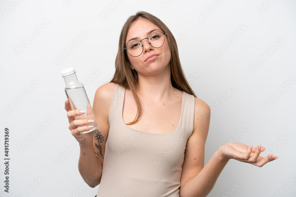 Young Lithuanian woman with a bottle of water isolated on white background making doubts gesture while lifting the shoulders Young Lithuanian woman with a bottle of water isolated on white background making doubts gesture while lifting the shoulders