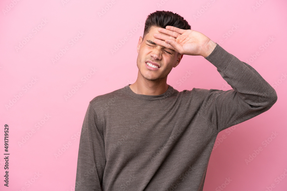 Young caucasian man isolated on pink background with tired and sick expression