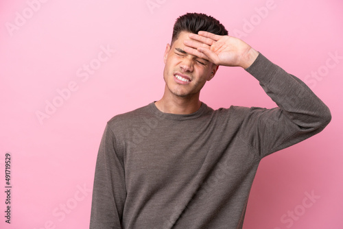 Young caucasian man isolated on pink background with tired and sick expression