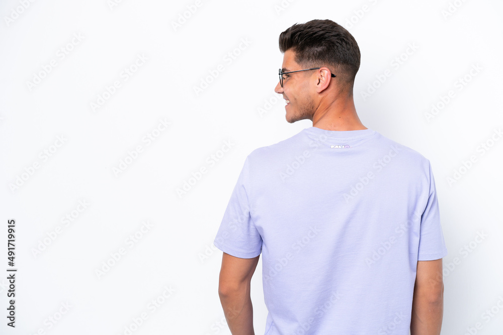 Young caucasian man isolated on white background in back position and looking side Young caucasian man isolated on white background in back position and looking side