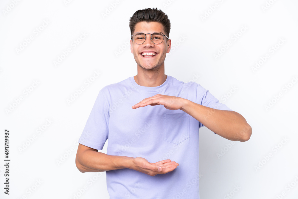 Young caucasian man isolated on white background holding copyspace imaginary on the palm to insert an ad Young caucasian man isolated on white background holding copyspace imaginary on the palm to insert an ad