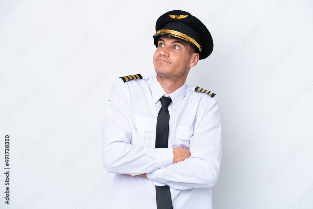 Airplane caucasian pilot isolated on white background making doubts gesture while lifting the shoulders