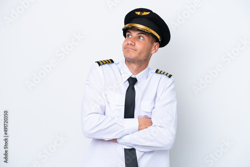 Airplane caucasian pilot isolated on white background making doubts gesture while lifting the shoulders © luismolinero