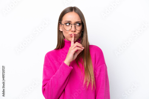 Young caucasian woman isolated on white background showing a sign of silence gesture putting finger in mouth