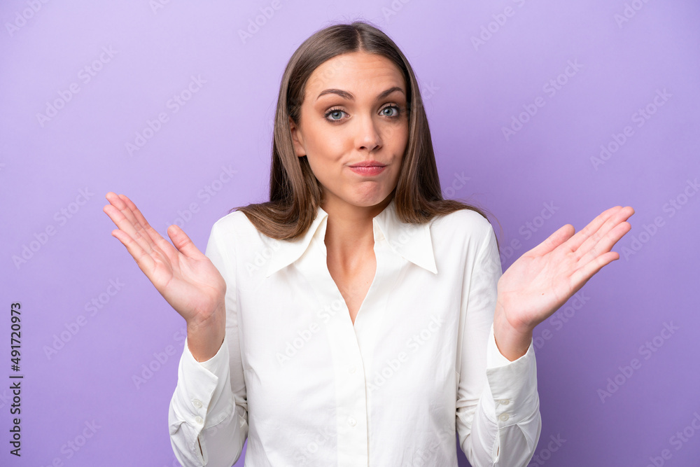 Young caucasian woman isolated on purple background making doubts gesture Young caucasian woman isolated on purple background making doubts gesture