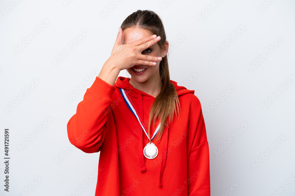 Young caucasian woman with medals isolated on white background covering eyes by hands and smiling Young caucasian woman with medals isolated on white background covering eyes by hands and smiling