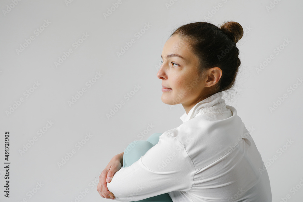 Side view portrait of young pretty woman wearing white shirt posing on white. Side view portrait of young pretty woman wearing white shirt posing on white.