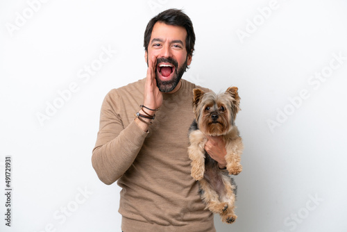 Man holding a yorkshire isolated on white background shouting with mouth wide open