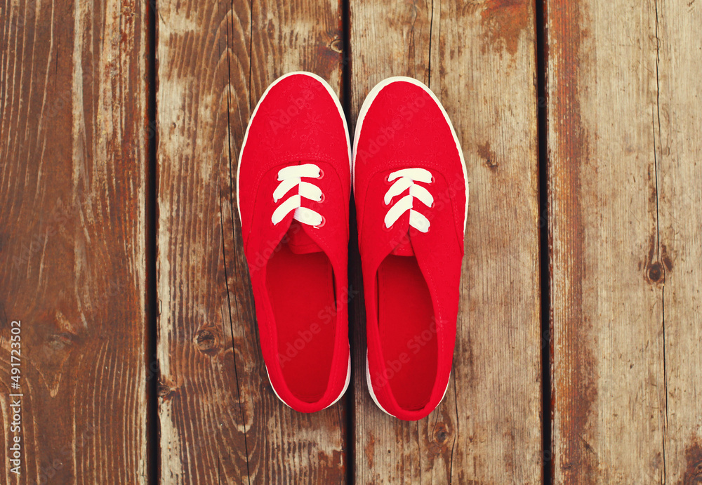 Summer image of pink gumshoes on a wooden table or floor background, top view Summer image of pink gumshoes on a wooden table or floor background, top view