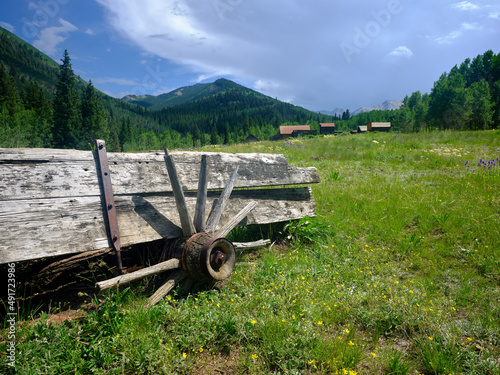 Color image of an old Conestoga wagon on the outskirts of a ghost town in the Colorado Mountains photo