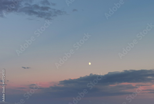 Tre quarti di Luna nel cielo prima del tramonto photo