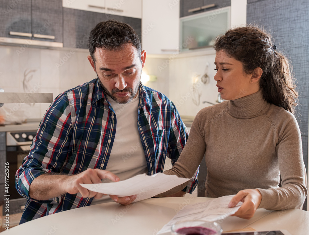 Wife showing her husband bills they have to pay. Wife showing her husband bills they have to pay.