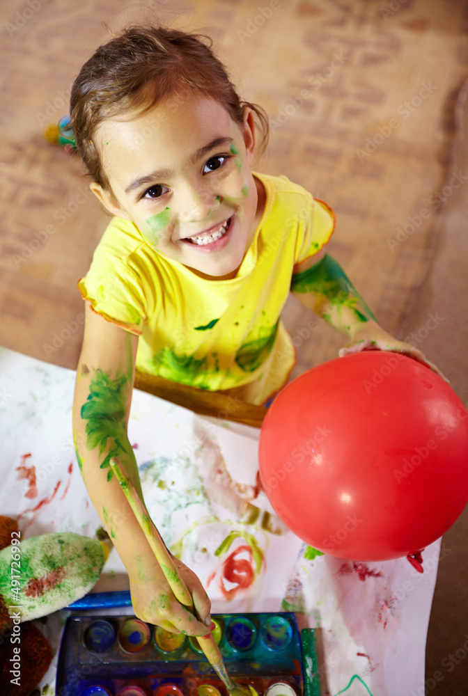 Fototapeta premium Wanna see me make magic with paint. Shot of an adorable little girl making a mess while painting.
