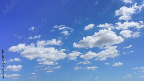 Puffy white clouds and blue sky suitable for background or sky replacement.