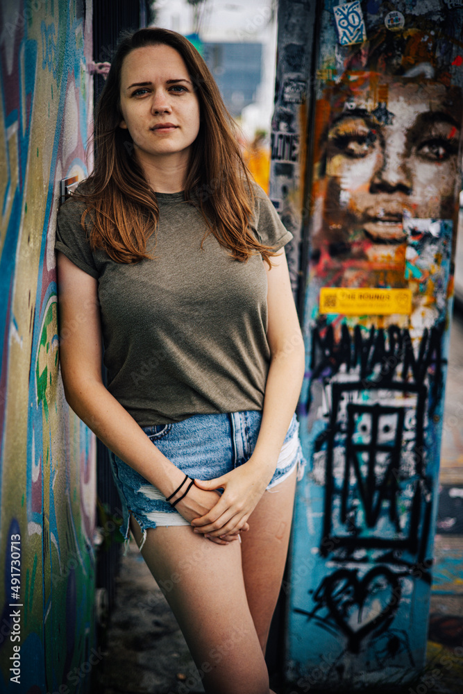 Naklejka premium Beautiful female street fashion model poses for the camera in the colorful streets of Miami - travel photography