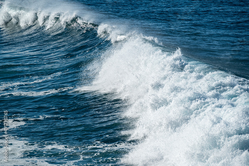 Full frame shot of the deep blue Atlantic Ocean and a beautiful wave crashing on the coast of Paul do Mar  a popular surf spot on Madeira island  Portugal