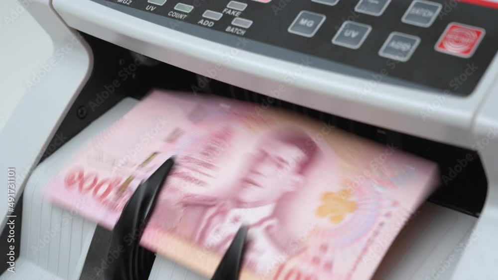 Slow Motion Shot of Thai Baht money counting in Machine. Paper THB Thai baht banknotes. Fast cash note count in Machine Counting. Business and economy in Thailand concept.