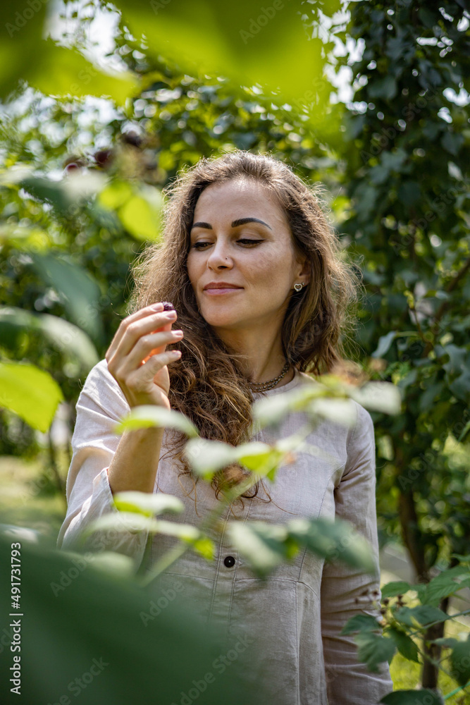Portrait of Young beautiful girl picks blackberries and raspberries in the garden Portrait of Young beautiful girl picks blackberries and raspberries in the garden