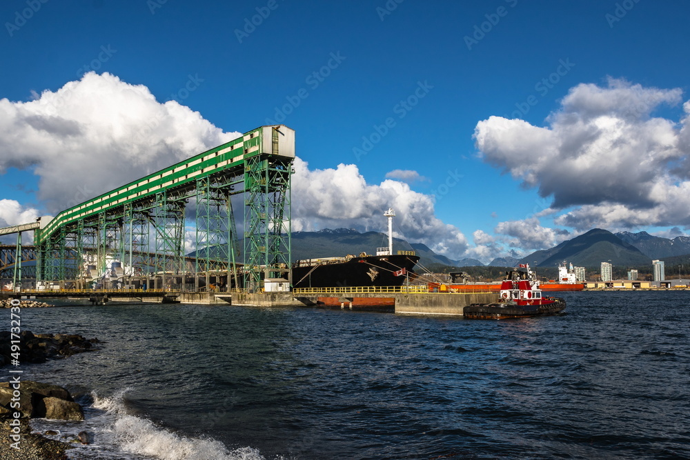 Ship under loading in sea port of Vancouver  on the background of blue cloudy sky, Vancouver Harbor, Second Narrowness Bridge