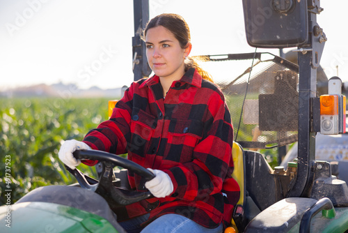 Portrait of a hardworking young farmer woman sitting at the wheel of an agricultural car. Close-up portrait