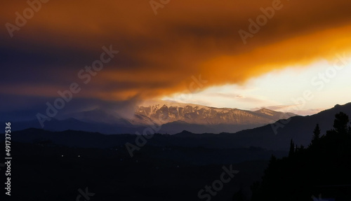 Rosso tramonto sulle cime dei monti tra luce e tenebre