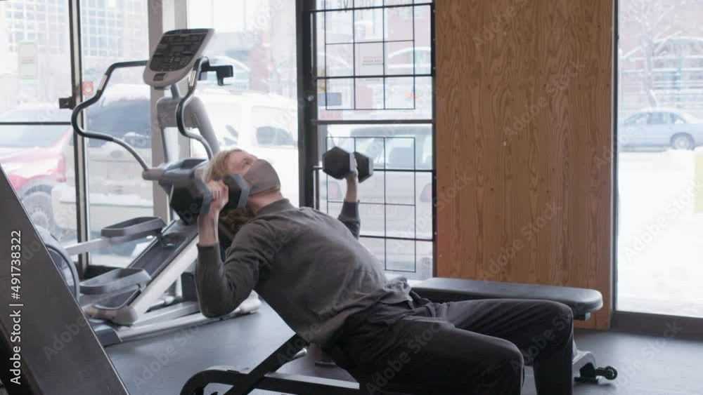 person doing inclined chest press with dumbbells person doing inclined chest press with dumbbells