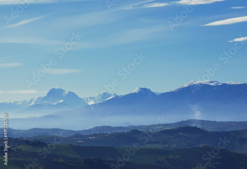 Montagne innevate e vallate nel cielo azzurro in una tersa giornata di sole invernale © GjGj