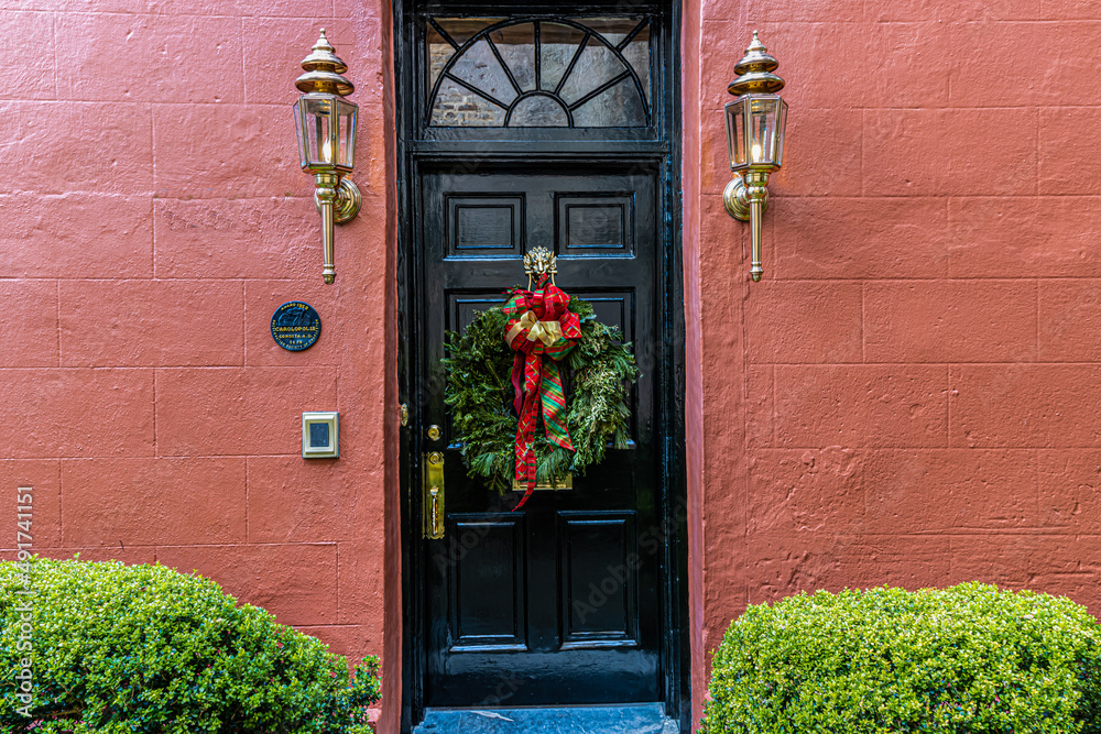 Fototapeta premium Black Door With Christmas Wreath in The Historic District, Charleston, South Carolina, USA