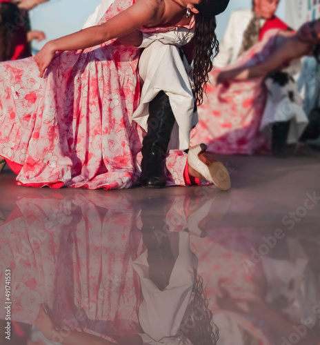Photo gaucho and paisana dance folklore in Argentina, dance step on mirrored stage