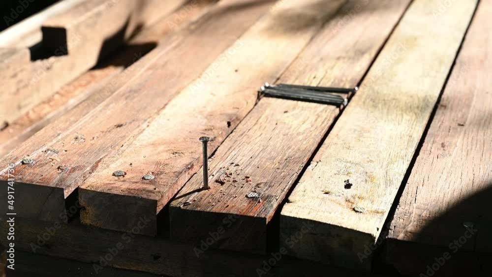 carpenter hammering nail into wood plank carpenter hammering nail into wood plank
