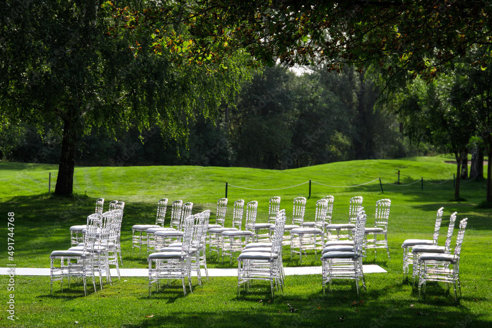 Transparent plastic chairs at a wedding ceremony in beautiful green lawn. Copy space Transparent plastic chairs at a wedding ceremony in beautiful green lawn. Copy space