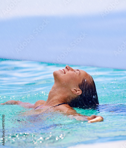 Having a tropical soak. Close up shot of a woman swimming in the swimming pool.