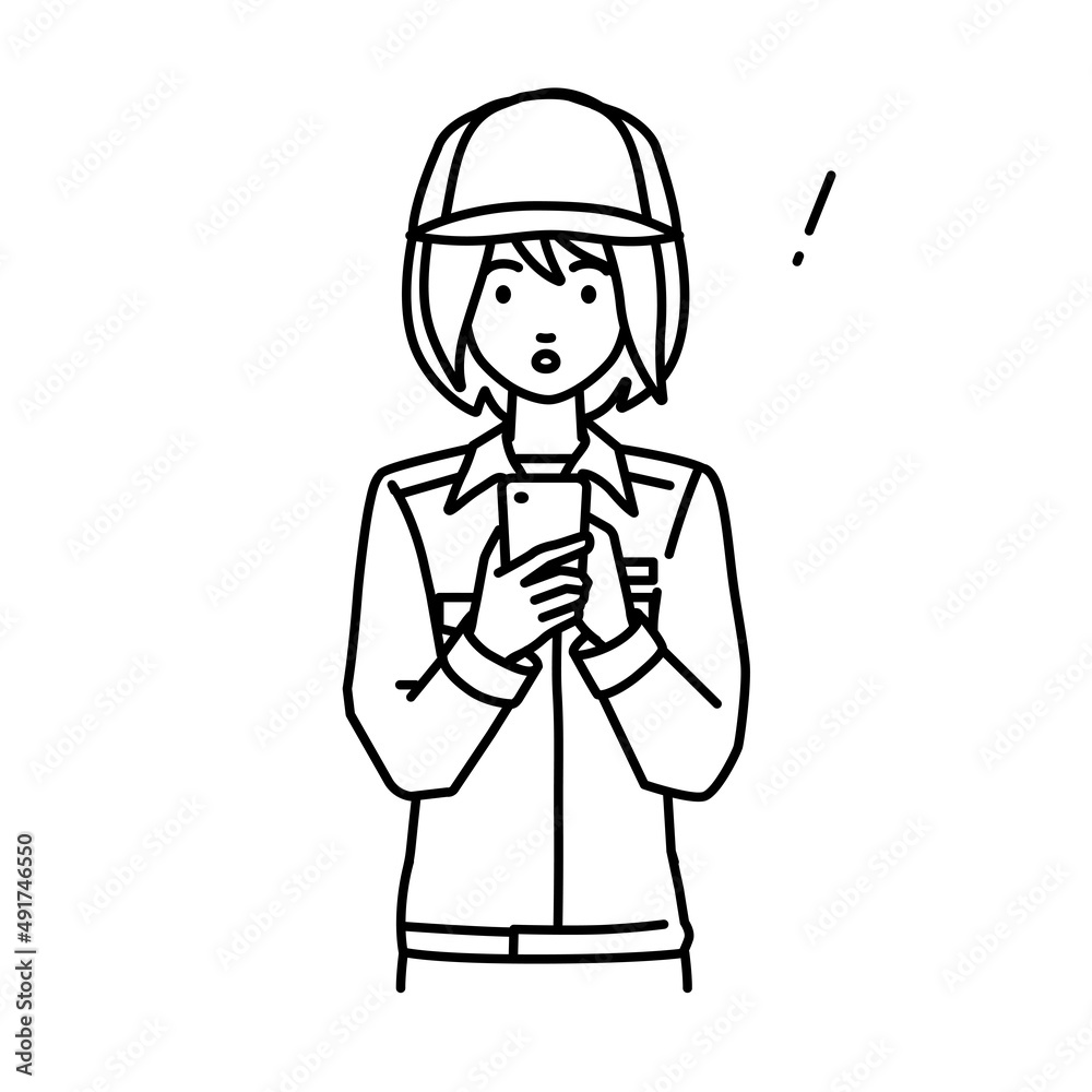 立ってスマートフォンを操作して何かに気づいて驚いた作業員の女性 立ってスマートフォンを操作して何かに気づいて驚いた作業員の女性