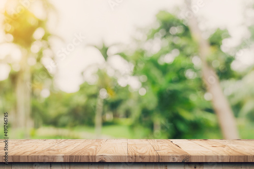 Empty wooden table top and Abstract blurred light bokeh and blur background of garden trees in sunlight. product display template with copy space.