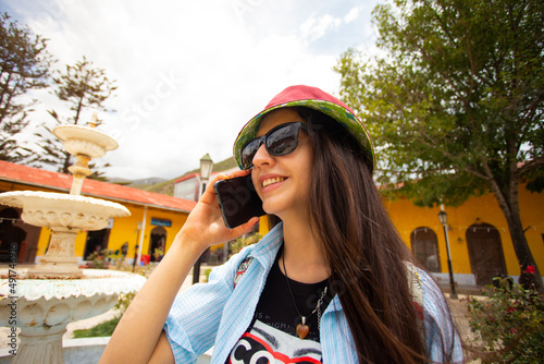 Turista hablando por teléfono en un pueblo de Perú photo