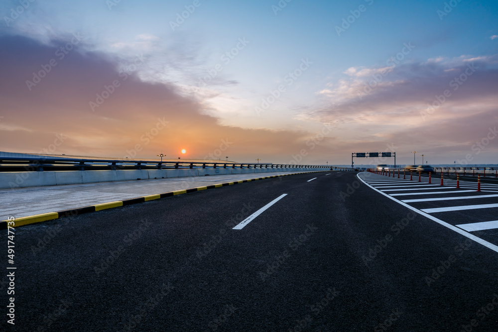 Fototapeta premium Asphalt highway and sky sunset clouds background